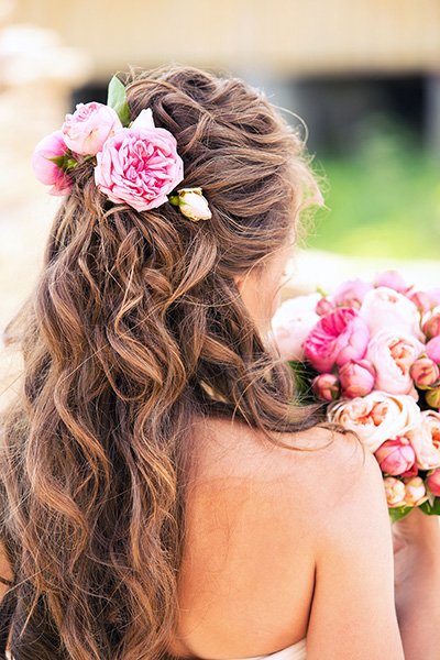 Capelli mossi castani legati dai fiori