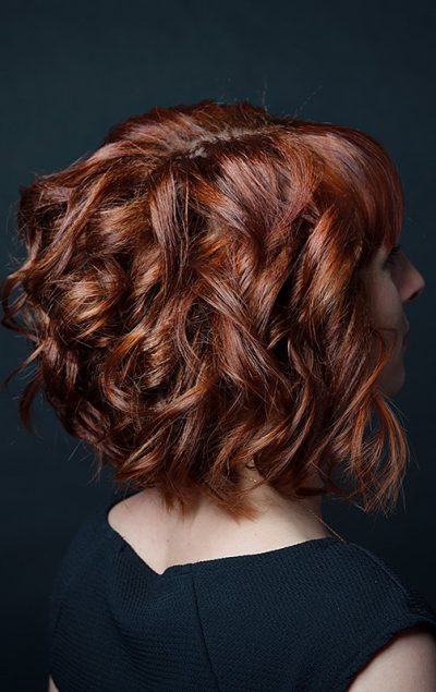 Capelli ondulati di lunghezza media e colore rosso, con mullet frontale