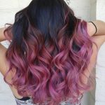 Capelli ondulati radici scure e punte rosa